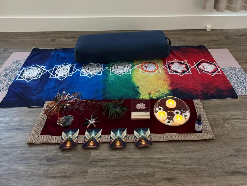 Guided meditation setup with chakra mat, oracle cards, crystals, candle bowl, bolster cushion, and healing tools